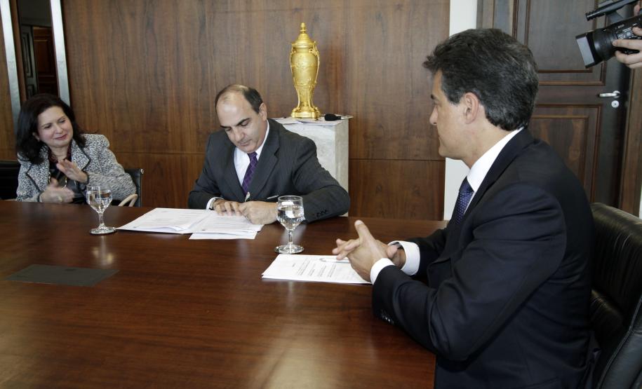 O presidente da Cohapar, Mounir Chaowiche, assina o convênio.