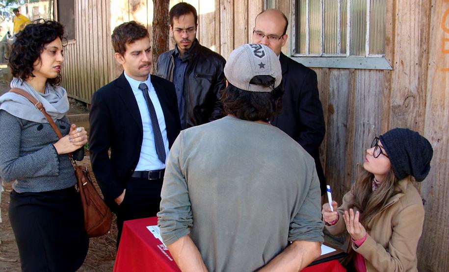 Os defensores públicos Camille Vieira da Costa, Bruno Passadore, Diego Cantoario, o subdefensor público-geral, Eduardo Abraão, e a assistente social Gabriele Rezende atendem a um morador da Ocupação Tiradentes.