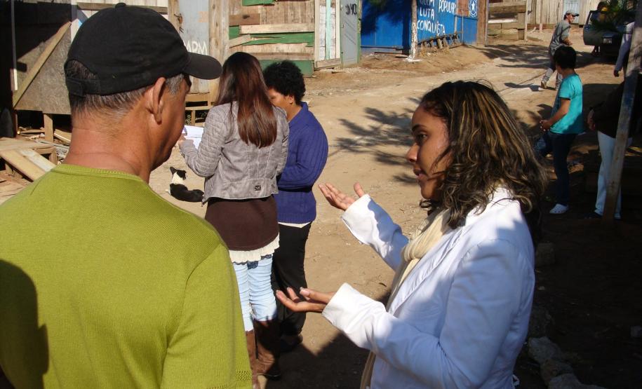 A defensora pública Flora Vaz Cardoso Pinheiro conversa com morador da Ocupação Tiradentes.