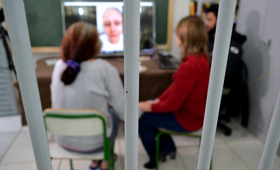 Detenta assiste a vídeo com depoimento de familiares durante encontro com equipe técnica da Defensoria Pública do Paraná.