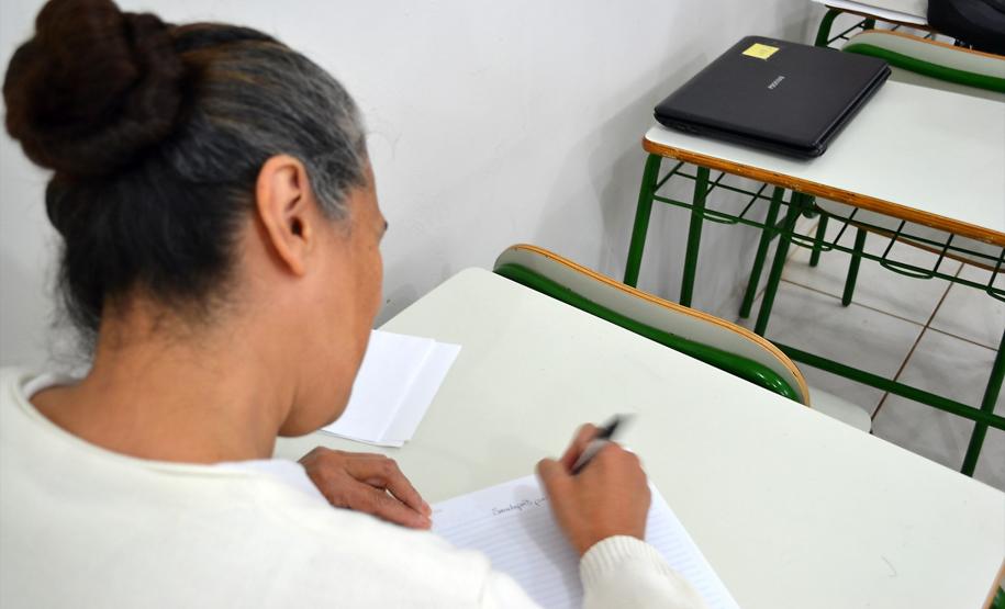 Mulher reclusa na Cadeia Pública Hildebrando de Souza, em Ponta Grossa, escreve carta a parentes durante atendimento da Defensoria Pública no local.