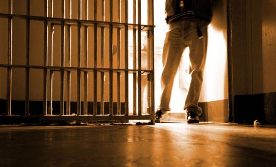 Setor de Execução Penal da DPPR provou que rapaz preso em flagrante não era o verdadeiro culpado. Descrição de imagem: na foto está  aparecendo um agente penitenciário da cintura para baixo abrindo uma cela.