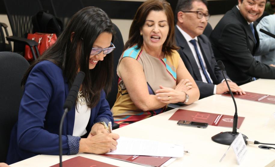 Coordenadora do NUCIDH, Cinthia Azevedo Santos assinando o Protocolo de Intensões para Formação da Rede de Atenção a Casos de Violação de Direitos de LGBT.